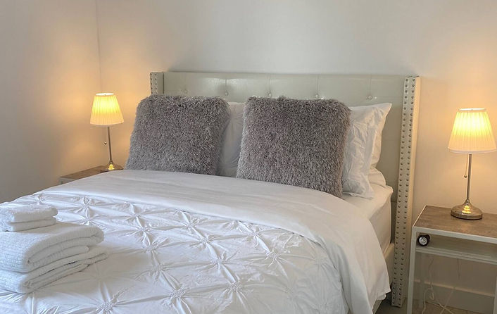 Stylish and serene bedroom at The Getaway Suites in Prince Edward County, featuring luxe linens and soft lighting for a relax