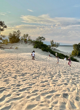 Scenic sunset at Sandbanks Provincial Park in Prince Edward County, with families enjoying the sandy dunes and lake views.