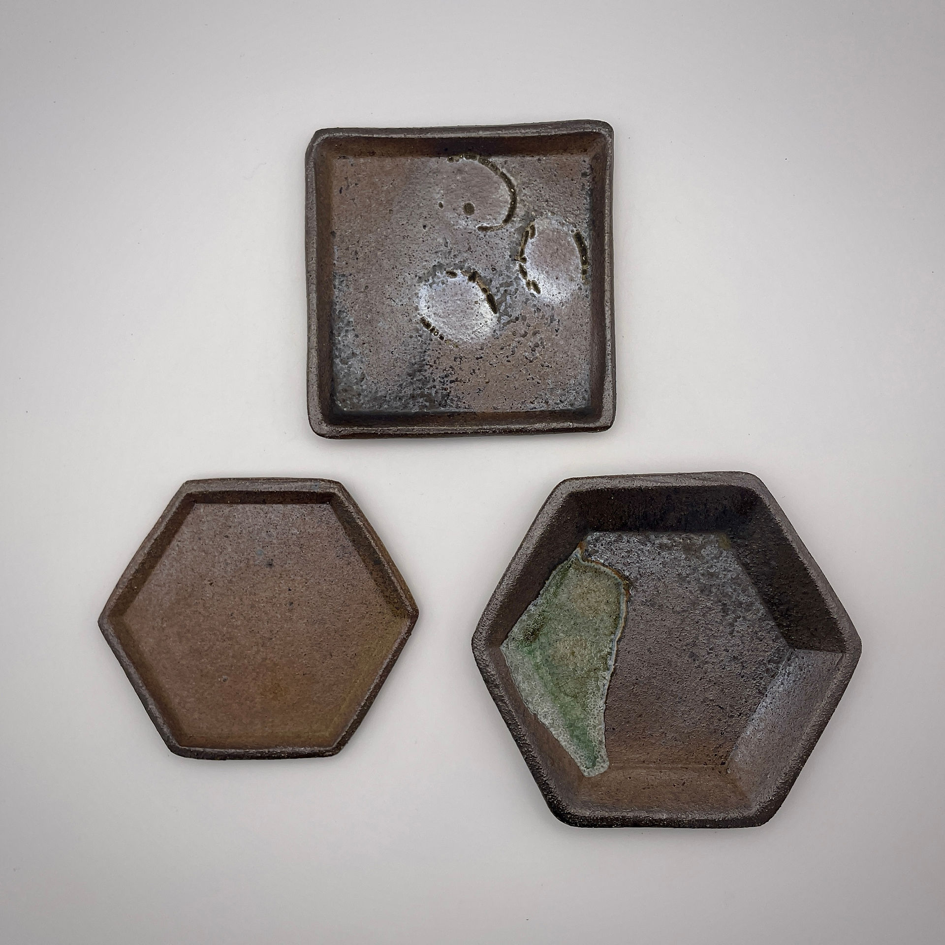 Three small plates: plain, with shells and with glass. Fired at the bottom of the kiln in flame line