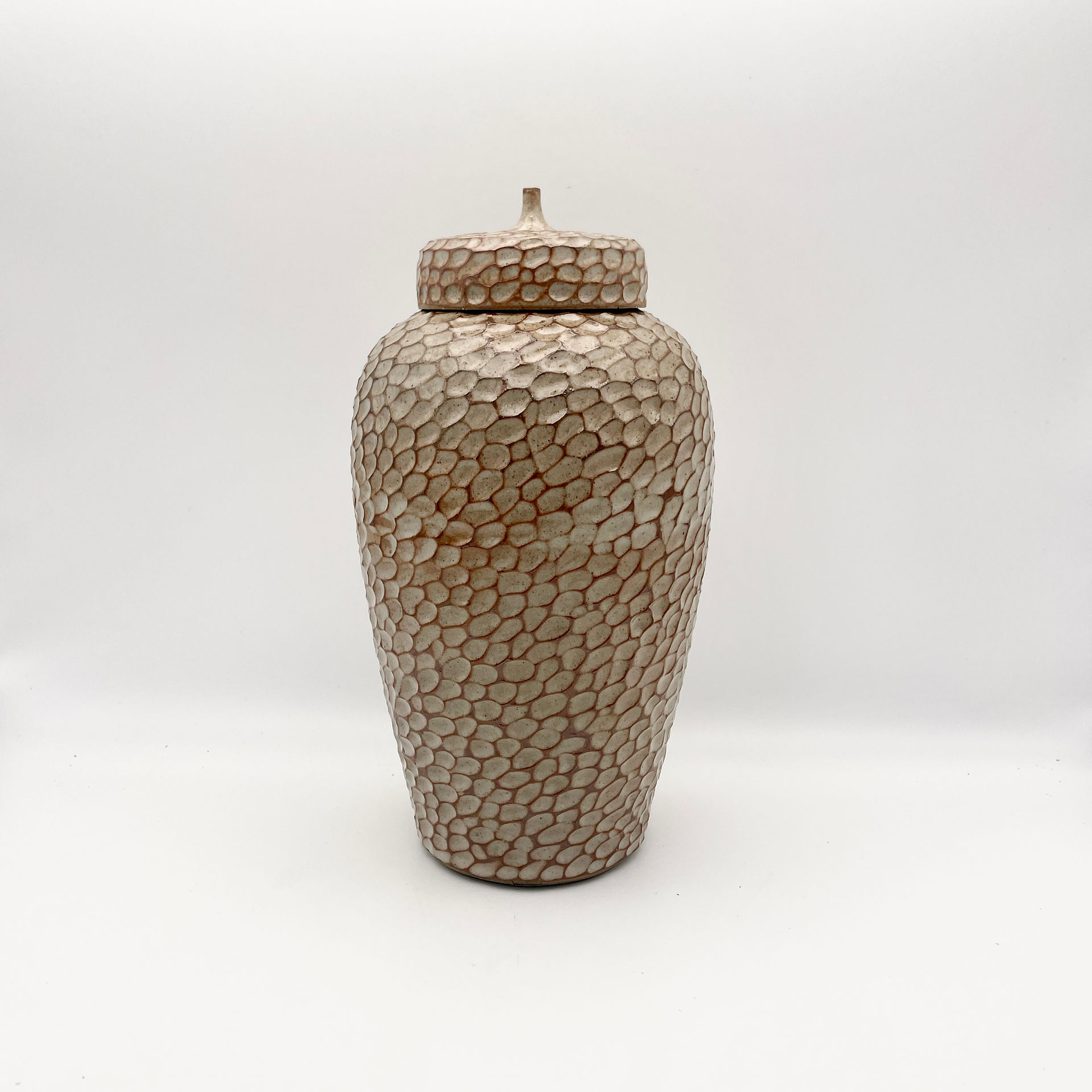 Tall carved lidded jar in Shino glaze.