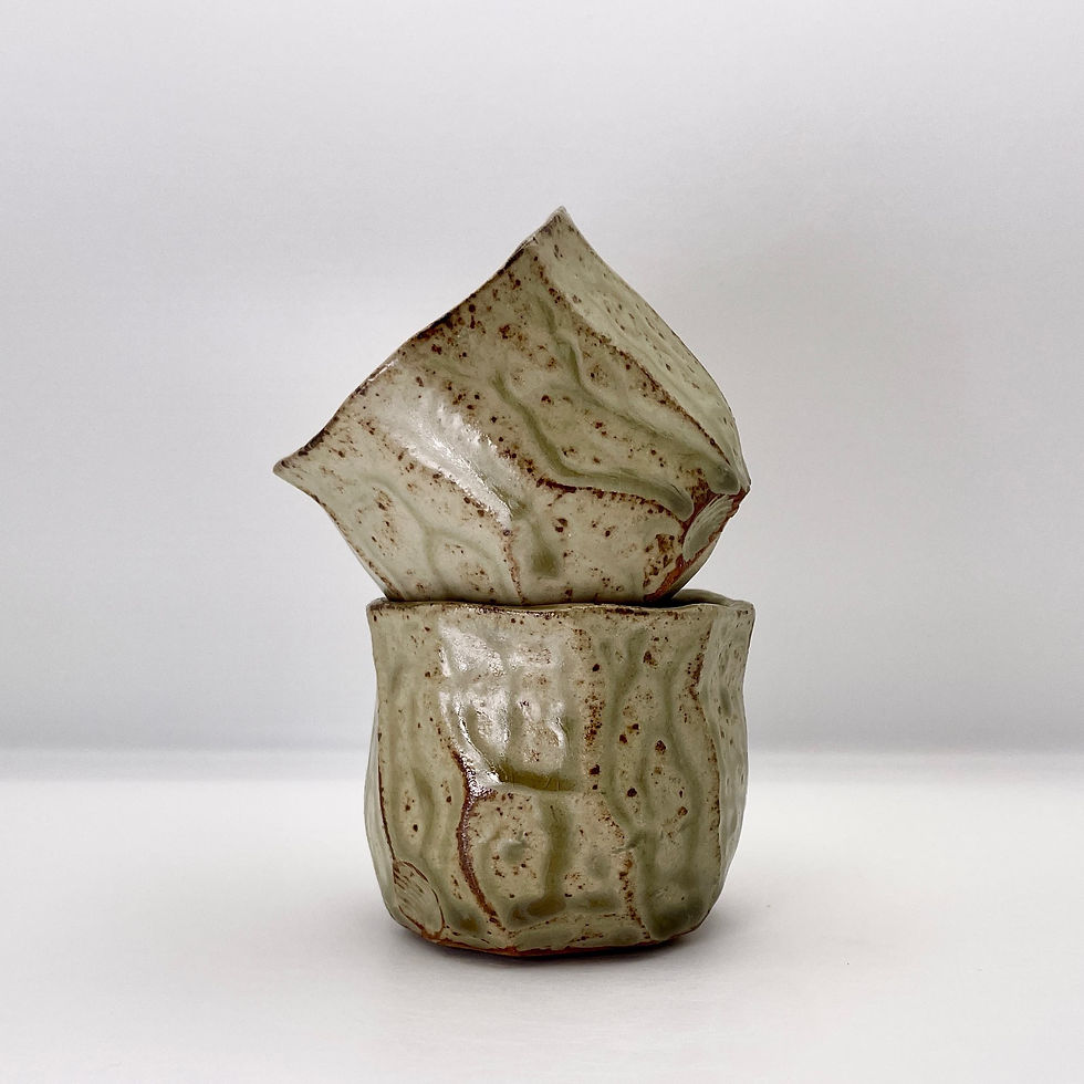 Faceted and altered cups in wood ash glaze.