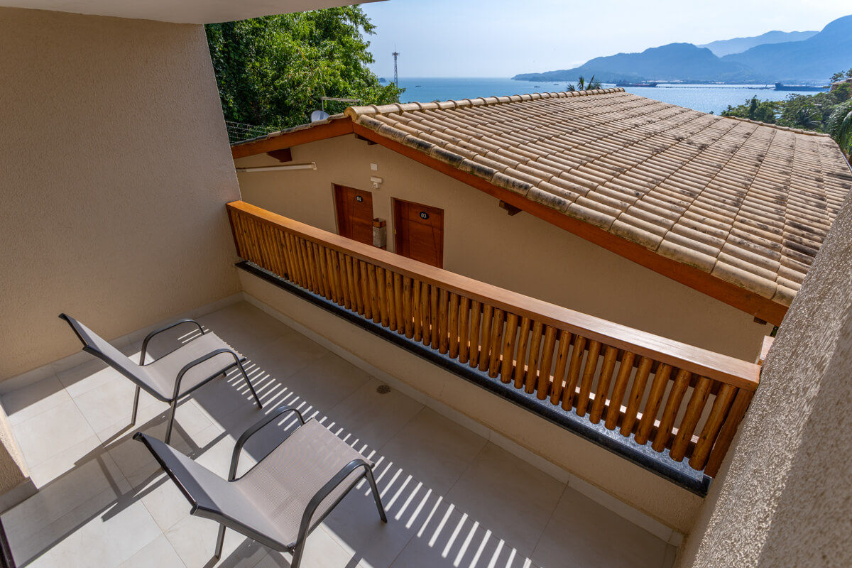 Varanda com duas cadeiras com vista para o mar e a serra de Ilhabela