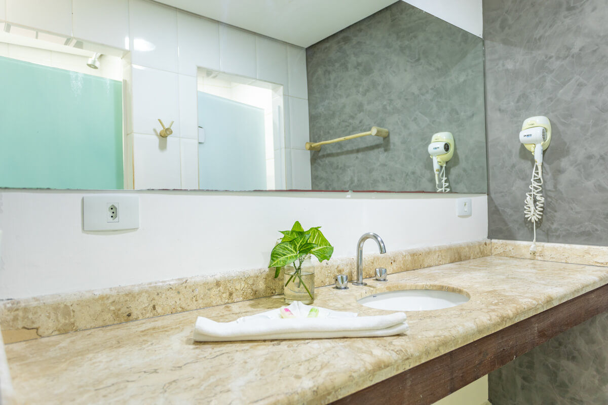 Lavabo com espelho, toalhas e secador de cabelo