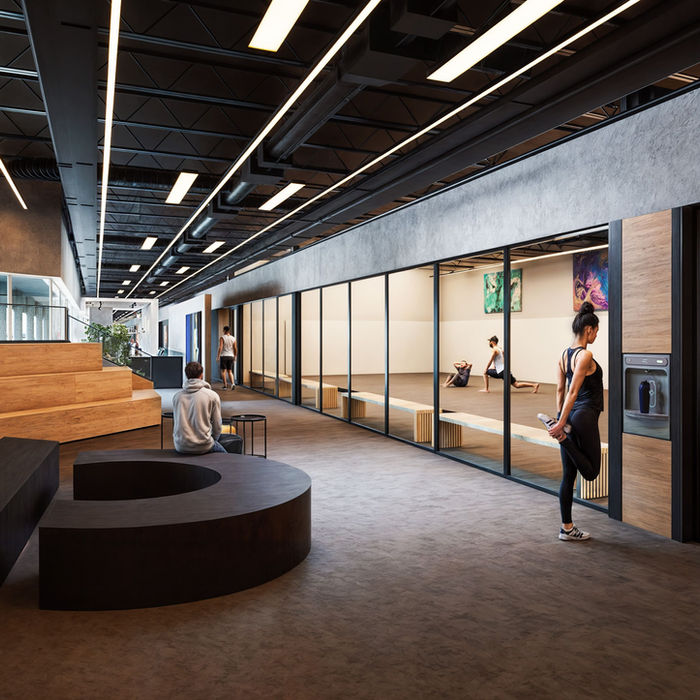 A large black geometric logo resembling a stylized "A" and a "C" or an ampersand symbol is prominently displayed on a white wall, at Trein Club in Houston