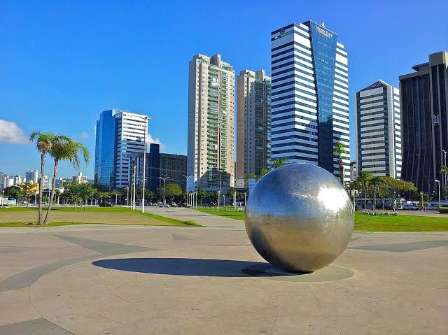 Vista panorâmica da Praça do Papa com vários prédios e uma bola de metal. 