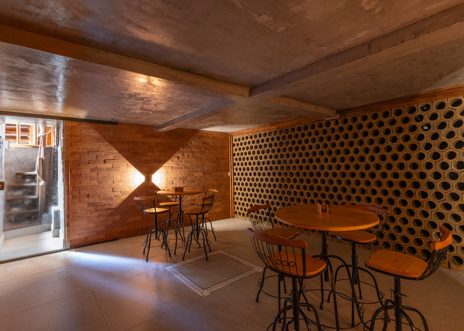 Vista da adega subterrânea climatizada com mesas e cadeiras para a degustação de vinhos na Pousada Cachoeira da Barra em Cunha