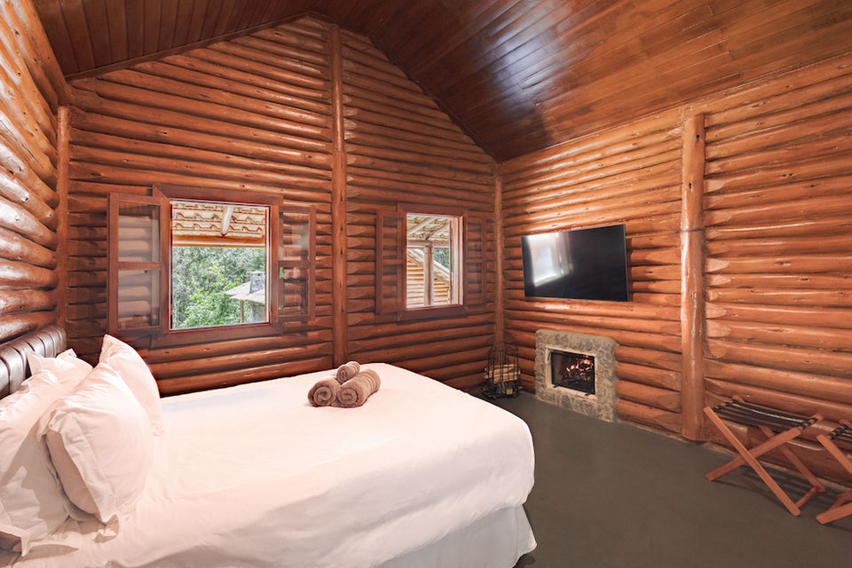 Chalé da Pousada Cachoeira da Barra em Cunha com paredes de madeira envernizadas e com duas camas de solteiro