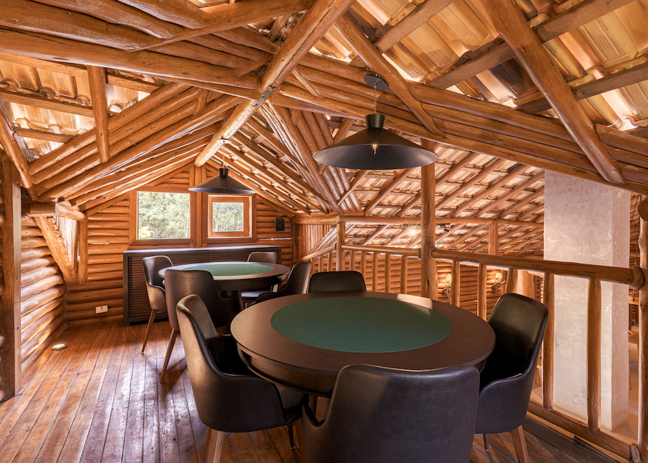 No segundo andar da Sala de jogos e cinema estão duas mesas redondas de carteado para os hóspedes aproveitarem a hospedagem em Cunha na Pousada Cachoeira da Barra