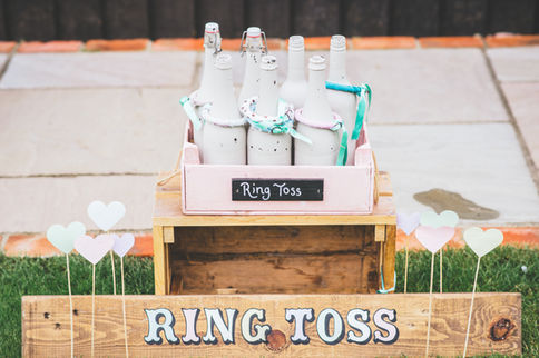 Ring toss game with a wooden crate and decorative bottles, a fun addition available for garden games hire at weddings and events.