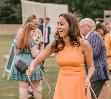 Vintage-style “Hoopla” game with pastel-striped towers, adding charming and playful entertainment to a wedding celebration.