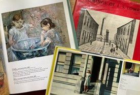 Open art books featuring paintings of children at a basin, an urban street scene, and a solitary figure on steps. Rich colors and diverse moods.
