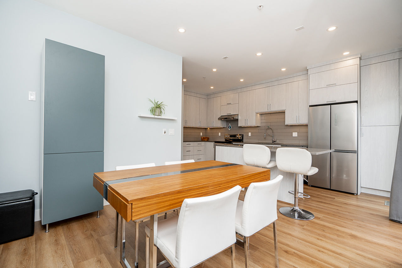 Modern open concept kitchen with new stainless steel appliances in Port Coquitlam townhouse.