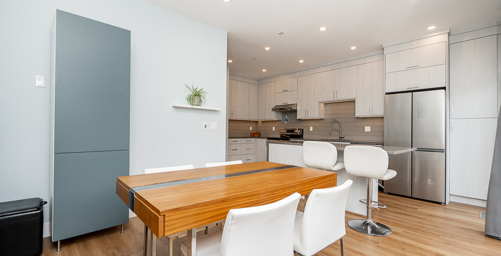 Modern open concept kitchen with new stainless steel appliances in Port Coquitlam townhouse.