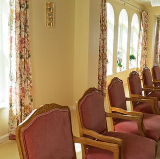 A row of chairs with west windows behind.