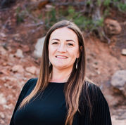 Woman in a black shirt standing in front of red rocks
