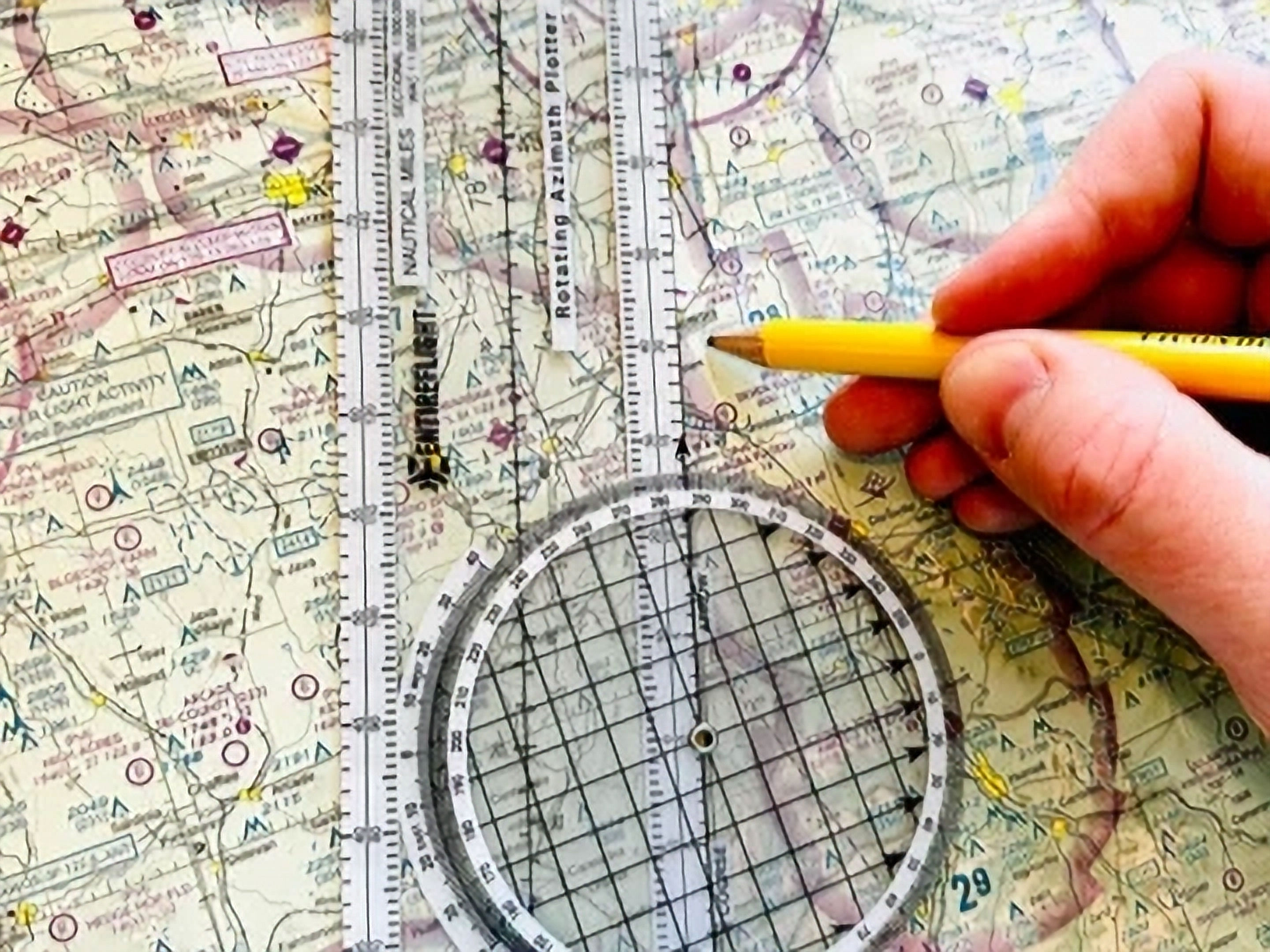 Pilot planning a flight course on a sectional chart