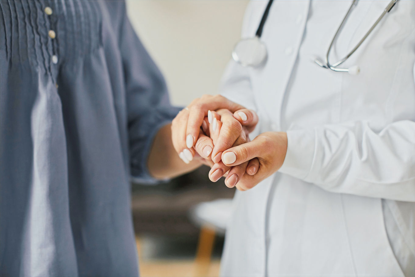 female doctor holding elderly patients hands