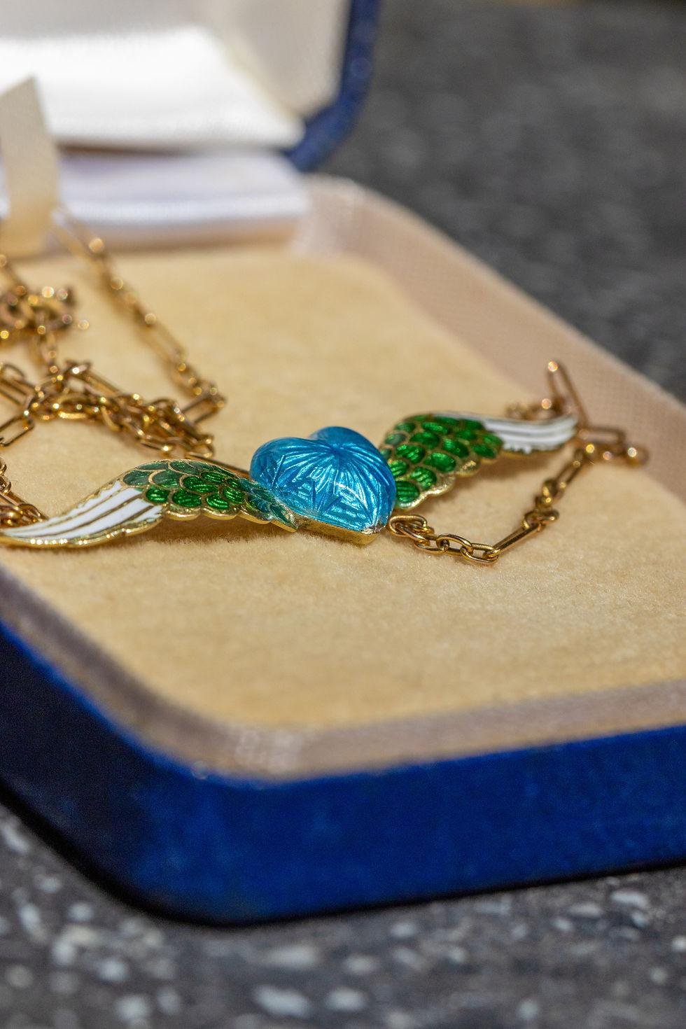 Miniatura: Macro image highlighting the intricate guilloché blue enamel heart and champlevé enamel wings of the Victorian pendant.