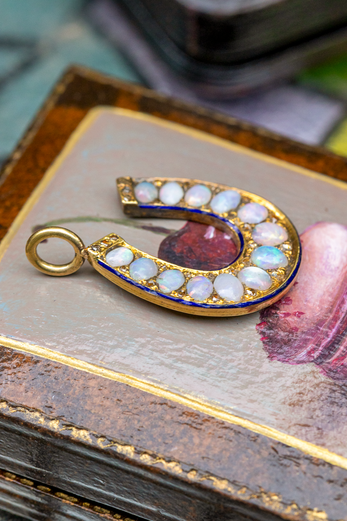 Thumbnail: Antique opal and rose cut diamond horseshoe pendant with blue enamel border in high carat gold on antique gold chain.