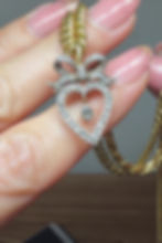 Миниатюра: Hand-held video of the Victorian witch’s heart pendant sparkling under warm lighting, showing off the dazzling diamonds.