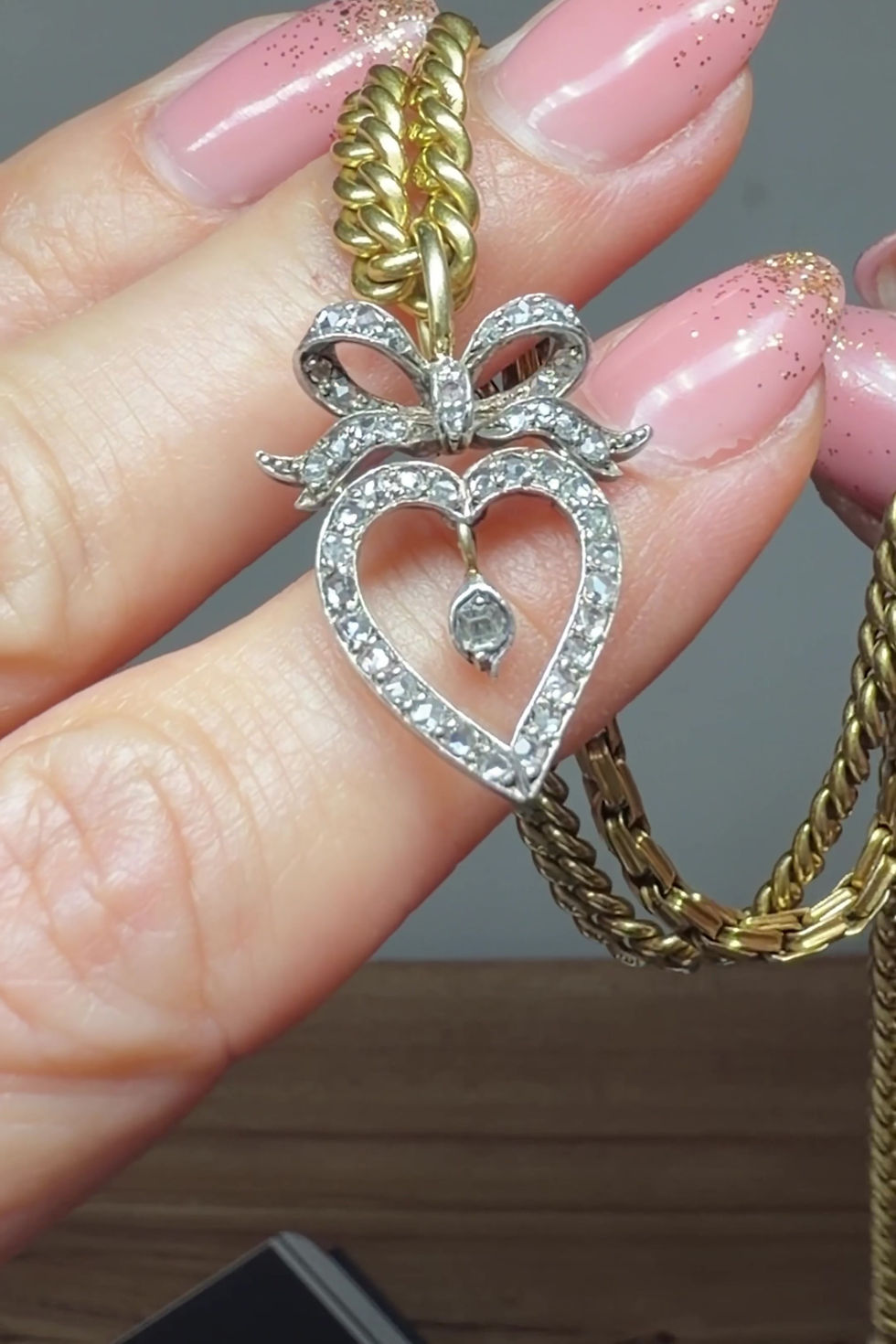 Miniatura: Hand-held video of the Victorian witch’s heart pendant sparkling under warm lighting, showing off the dazzling diamonds.