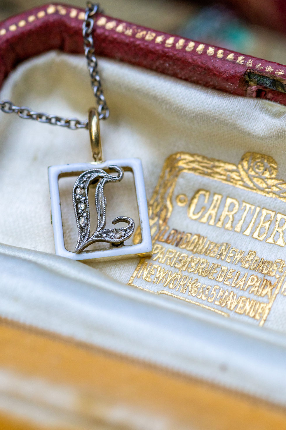 Close-up of diamond-set "L" showcasing delicate antique craftsmanship and enamel detail.