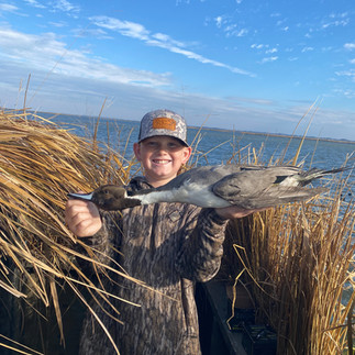 Boy Holding a duck he just shot on a hunt