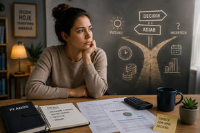 Pessoa refletindo diante de uma mesa de trabalho, simbolizando o impacto da procrastinação nas decisões financeiras e no planejamento do futuro.