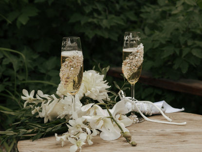 Two champagne glasses with flowers.