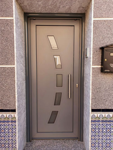 Do you want to add security and style to the entrance of your home? Discover our PVC street door in elegant silver color 7012, designed to offer you maximum protection and a touch of class.

At EP Cristalería y Ventanas, we understand that the entrance door is the first impression of your home, which is why we offer a high-quality PVC door in a modern and sophisticated 7012 silver finish. Equipped with a 3-point security lock, you can rest easy knowing that your home is protected from unwanted intruders.

Personalize your door with a decorative panel according to your tastes and preferences, adding a unique and personalized touch to the facade of your home. In addition, our 7012 silver PVC door is designed to resist the elements and maintain its impeccable appearance over time.

Trust EP Cristalería y Ventanas to offer you the best quality and service. Contact us today to learn more and discover how our 7012 Silver PVC Front Door can improve the security and style of your home!