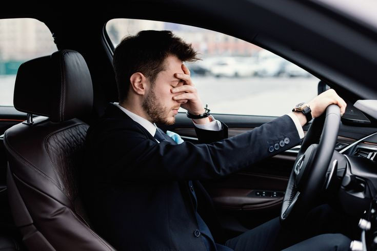 Hombre estresado en un carro.