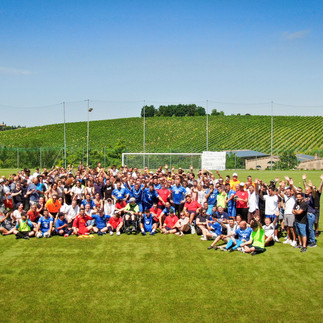 Foto di gruppo dei partecipanti in mezzo al campo di calcio