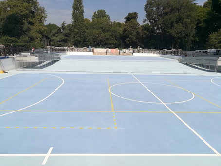 Immagine di un campo sportivo immerso in un parco cittadino