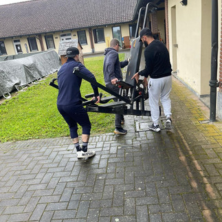 i ragazzi della comunità iniziano i lavori della palestra portando via le vecchie attrezzature