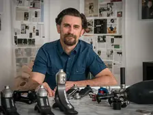 Daniele Bonacini seduto a una scrivania sulla quale ci sono le sue protesi