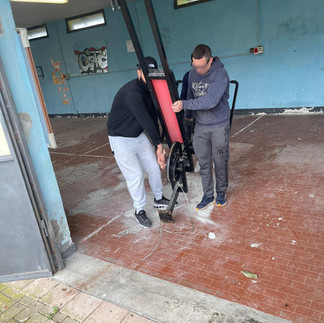 i ragazzi della comunità iniziano i lavori della palestra portando via le vecchie attrezzature