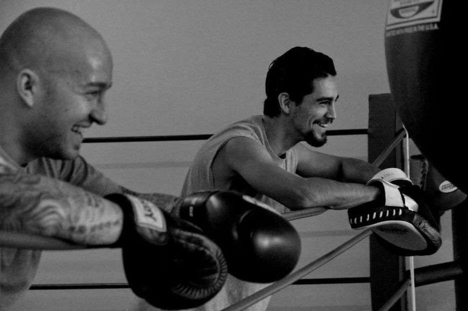 Paulie boxing consulting and teaching client about balance and coordination.