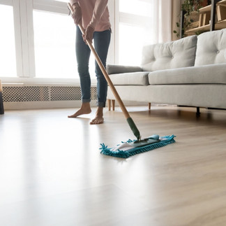persona limpiando su piso laminado con un trapeador de tela
