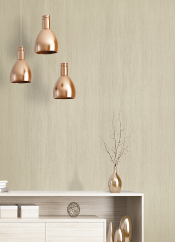 Copper pendant lights hang over a beige sideboard with decor including a vase and branches, set against a light, textured wall.
