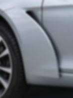 Professional car detailing on a silver sedan fender.
