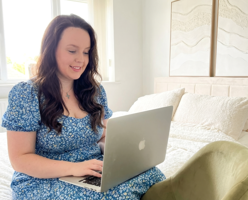 arroe sat on bed with laptop