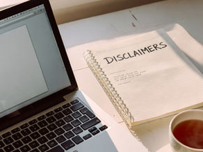 UK digital product seller's desk with laptop and notes on legal disclaimers