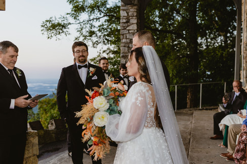 Bride walking down the aisle with her dad. The groom is looking at the bride and the clouds can be seen behind you.