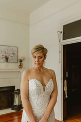 Bride is in the bridal suite she is looking down in her wedding dress.
