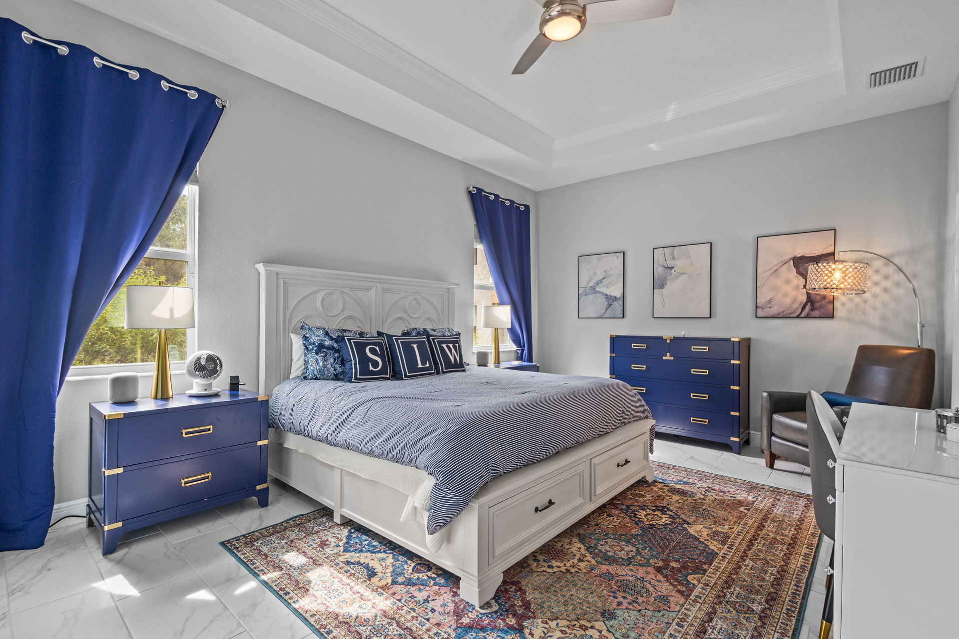 large master bedroom with king bed and blue curtains