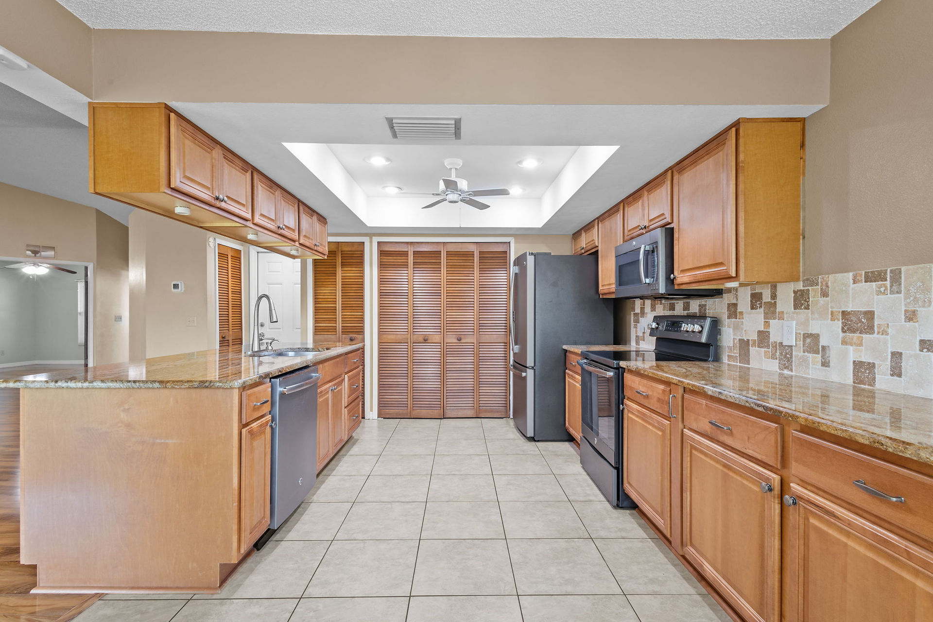 open kitchen view of counterspace and appliances withwood cabinets