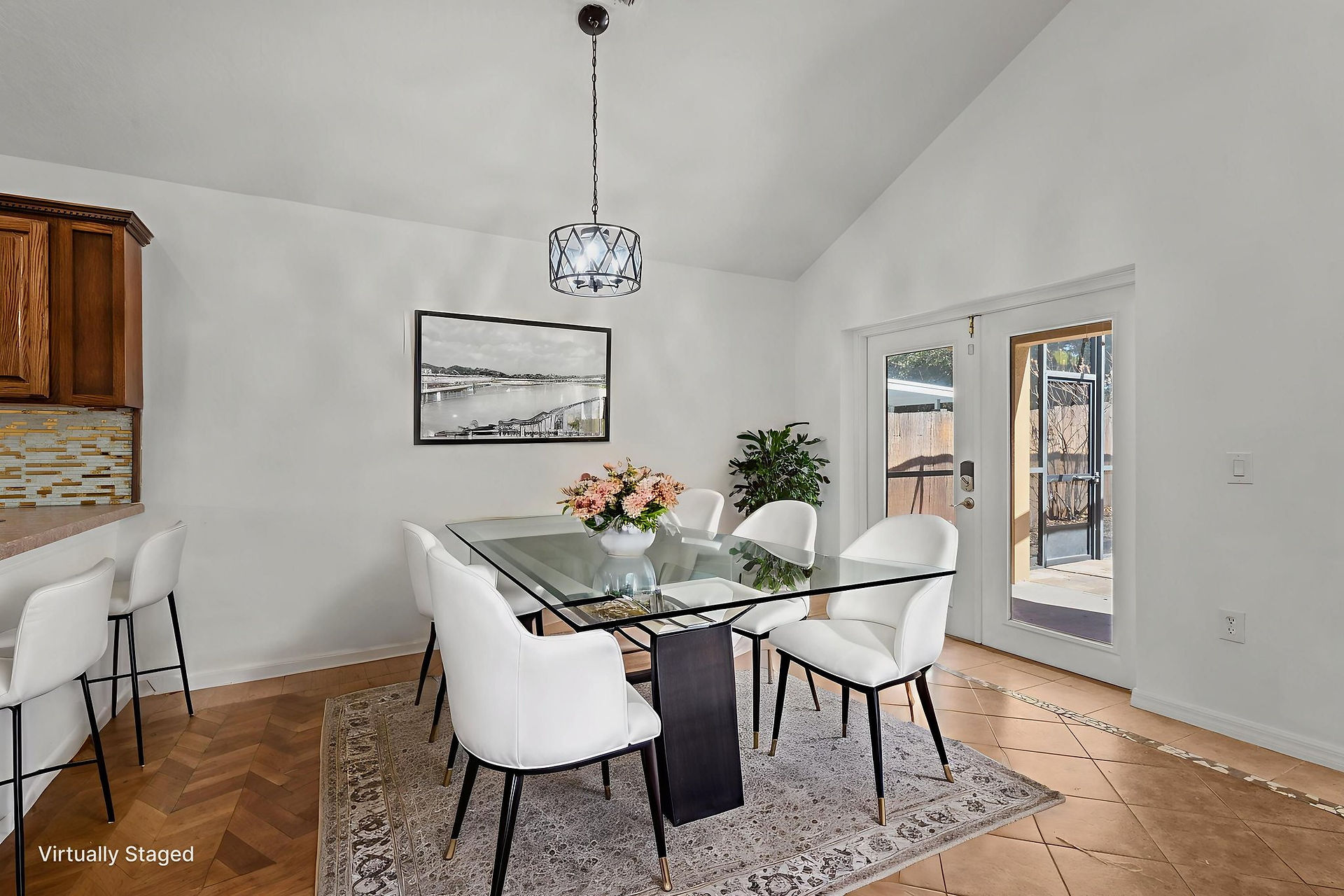 Virtually staged dining room with a glass table and white chairs, doors leading to the lanai