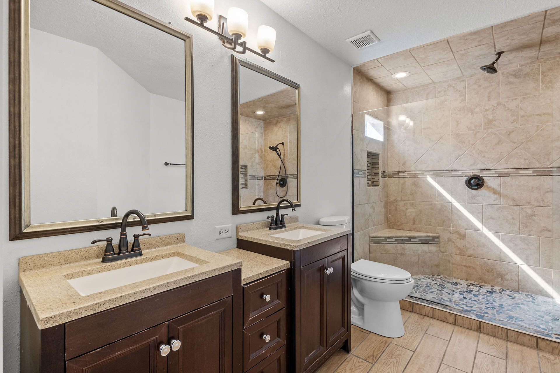 Master bathroom with dual sinks dark wood cabinests, walk-in shower