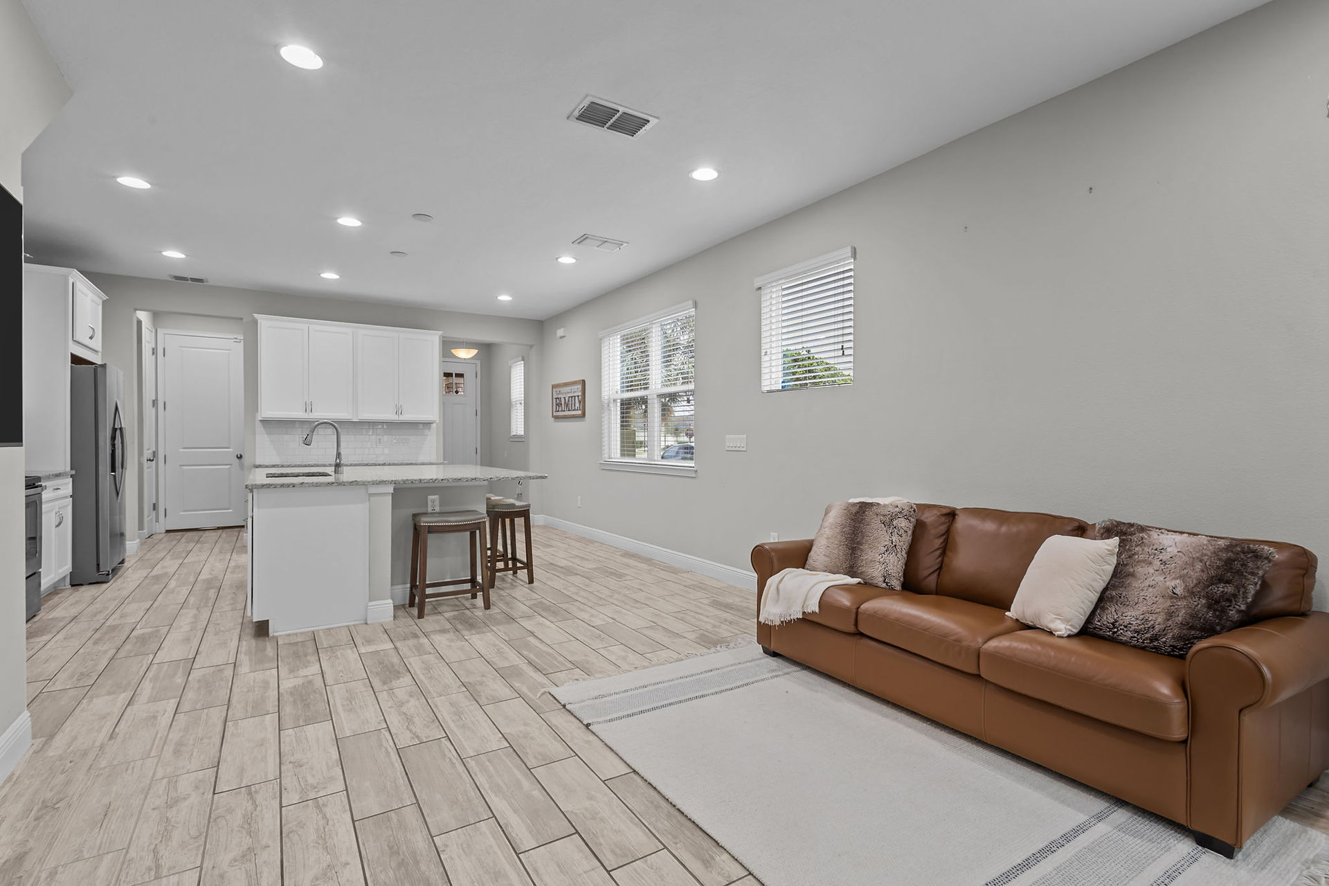 brown couch in living area with view into kitchen