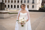 bride holding floral bouquet in city settings